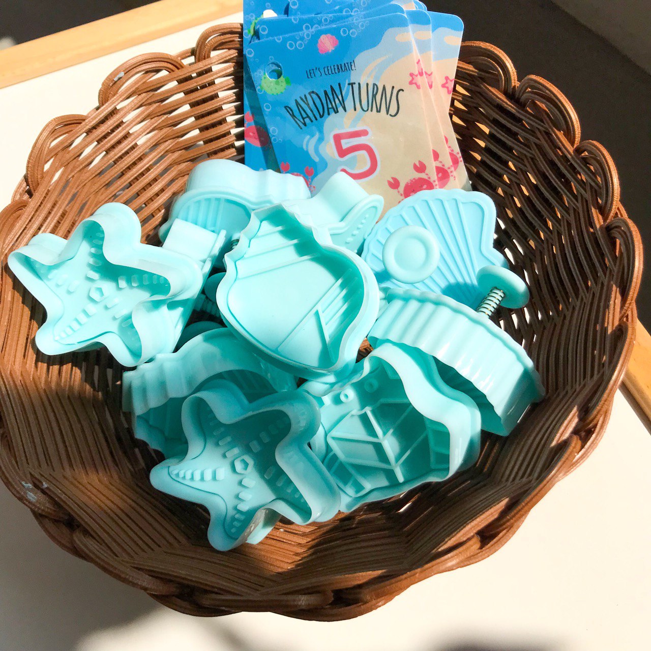 A brown basket filled with a set of ocean themed playdough stampers