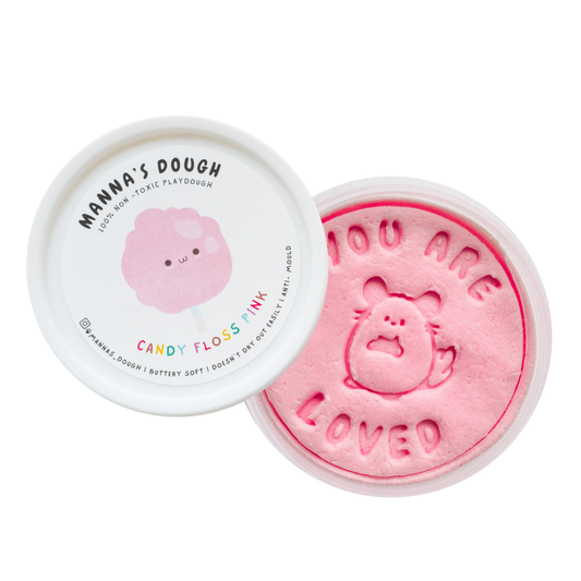 pink playdough from Manna's Dough, labeled 'Candy Floss Pink' with a cute cotton candy design on the lid. The soft, non-toxic playdough is stamped with 'YOU ARE LOVED' and a charming candy floss character, perfect for safe and creative play.