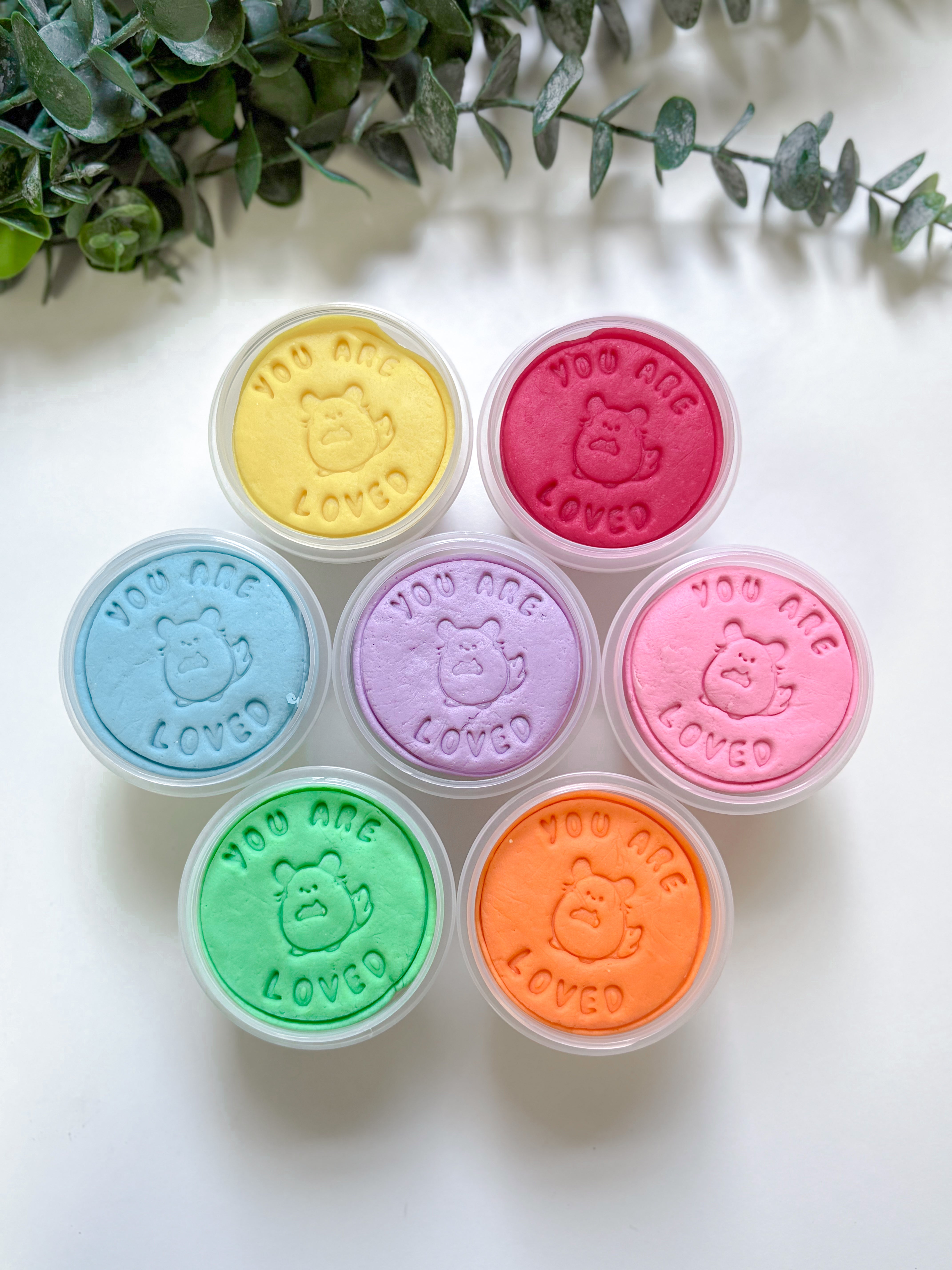 Set of colorfuplaydough tubs with a cute animal design and 'You are loved' text on a white background.