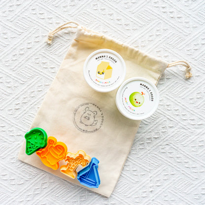 Colorful cookie cutters with a branded drawstring bag on a textured white background