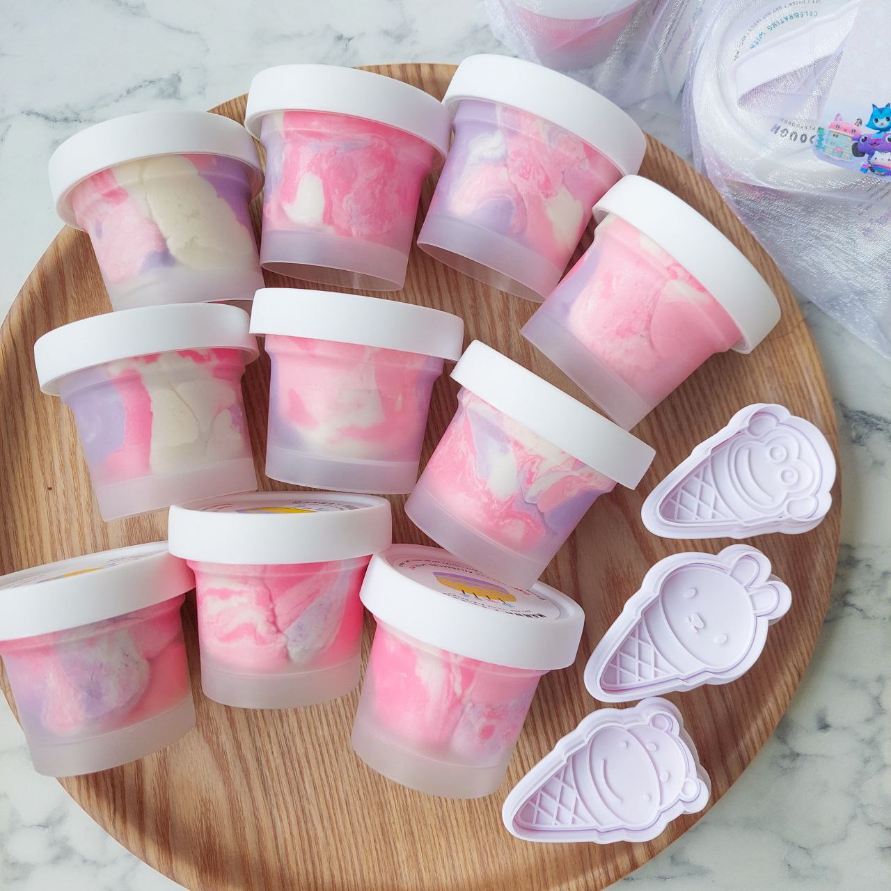 A set of 9 playdough marbled tubs and 3 ice cream stamper featuring a monkey, rabbit and hippo